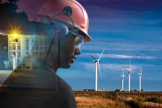 Male engineer in hard hat in field with wind turbines