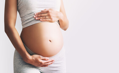 Close-up pregnant woman's belly on white background