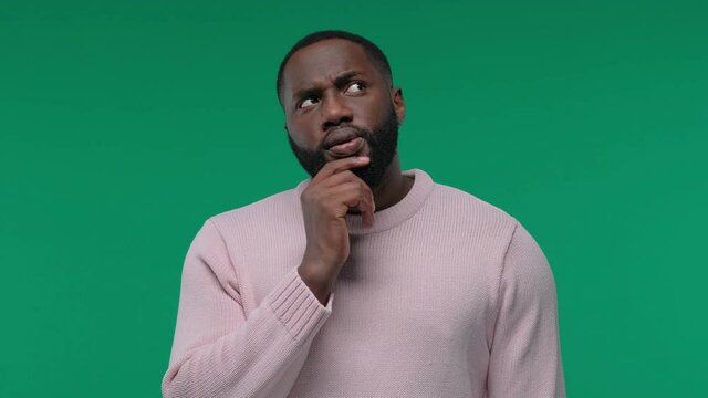Young African American man thinking and looking up, on Green Screen, Chroma Key