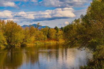 Missisquoi river in autumn with Jay Peak in the distance in Vermont 
