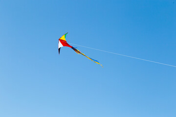 kite on the blue sky in sunny weather and wind. Kite flying in summer with copy space. Liberty.
