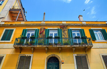 Lisbon, Portugal. Street with buildings with yellow walls and blue sky. Summer, sunny day.