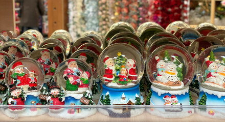 Glass balls with Santa Claus inside. Supermarket of Christmas decorations. A counter with Christmas decor.