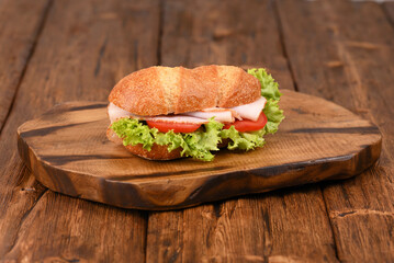 Juicy bread roll with mayo, green salad, tomatoes and ham.