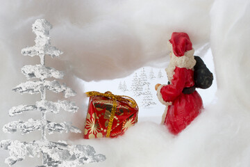 Santa claus in snowstorm with sack and gift, trees