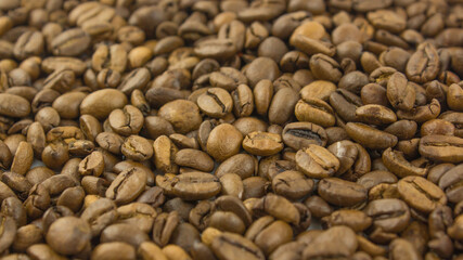 Close-up of coffee beans. Roasted grains of aromatic coffee lie on a plate.
