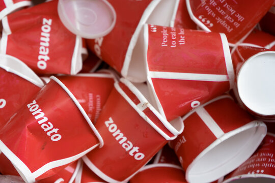 Crushed Disposable Cups With The Red Color And Branding Of Zomato At An Event Sponsored By The Food Tech Unicorn Startup