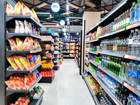 Shot of shelves of retali store filled with bottled water and snack items like chips and treats from some of the top brands in India