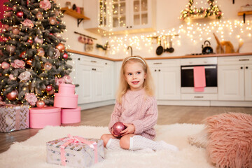 little girl sits on the floor under the tree, New Year's photo session in the studio, lights