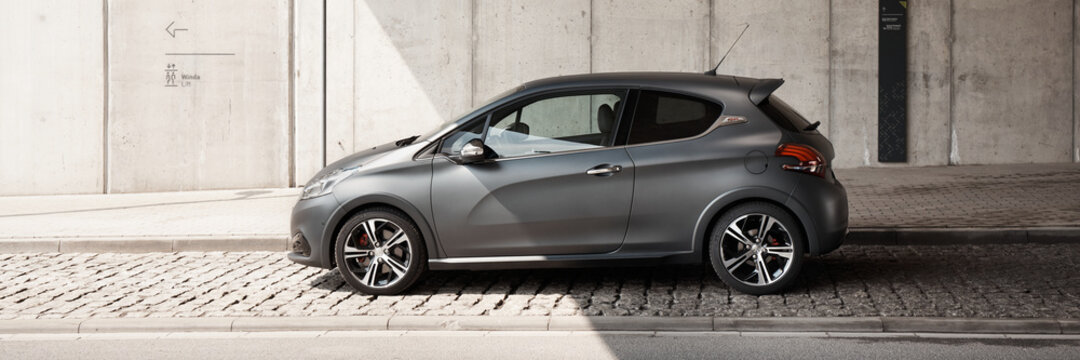 Katowice/Poland-05.05.2016: Grey Peugeot 208 GTI with original matt varnish standing under the concrete wall of the Silesian Museum. Cult hot hatch, fast and agile. Engine 1.6l, 208 hp, 6.5s 0-100km