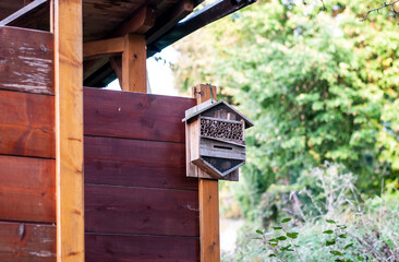 a small wooden insect hotel in a garden
