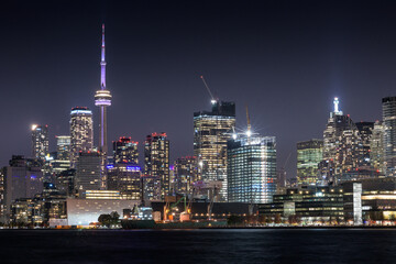 Toronto skyline at night featuring the CN tower and waterfront. 