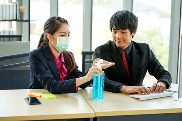 business woman worked in the office wearing surgical face mask to prevent from virus pandemic with her colleague employee social distancing new normal safety fro covid-19 virus corona pandemic