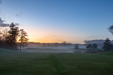 Fototapeta na wymiar Sunset landscape with mist over a field