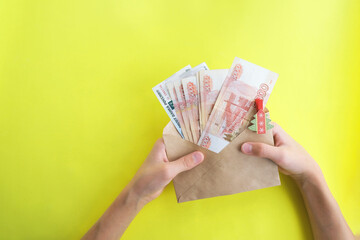 On a yellow background, an envelope with money, Russian five thousandth rubles. Economy concept,...