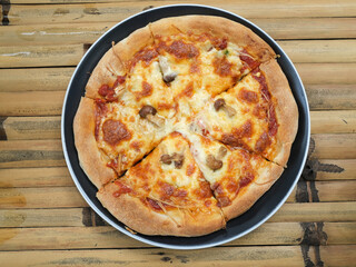 focus on mushroom tomato cheese pizza on the wooden table