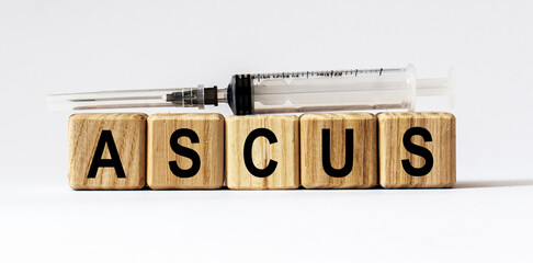 Text ASCUS made from wooden cubes. White background