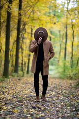 Man with cowboy hat covering his face in the forest