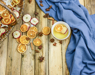 Weihnachtliche Dekoration mit Orangen und Apfelscheiben im Körbchen rustikal gestaltet mit winterlichem Tee