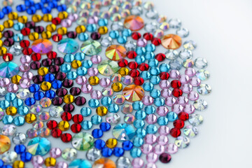 Acrylic stones of different sizes and colors top view. Multi-colored plastic stones for clothes and accessories. Decorative stones in red, yellow, pink and blue.