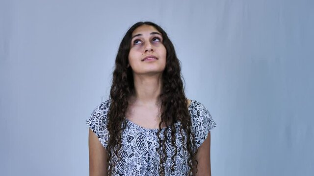 Teenage long haired girl looking upwards, isolated on white background
