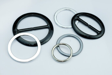 Injection molded plastic fittings for the belt of dresses or skirts. Black and gray plastic buckle for clothes. Plastic fittings on a gray background.