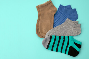 Knitted multicolored short socks on a turquoise background top view. Cotton sports underwear. Set of different socks with copy space. white casual soft socks perfect fit size walking going