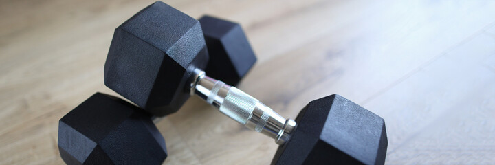 Close-up of metal heavy dumbbells for training home. Sport equipment for fit strong body. Fitness instrument on floor. Athlete and exercises indoors on quarantine concept