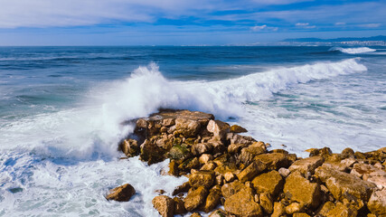 Aerial top view of Atlantic ocean big waves hitting on stone waterbreak 