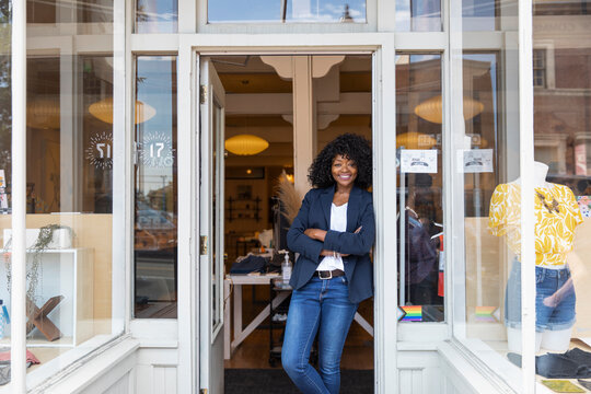 Portrait confident female shop owner in boutique doorway