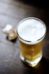 Glass of beer on dark wooden background.	
