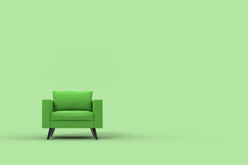Green armchair with pillows on studio green background.