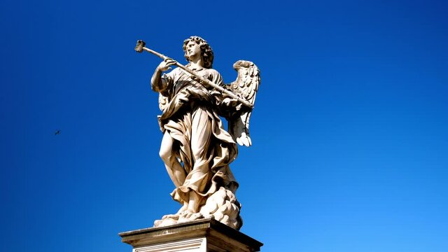 One of the Bernini's statues of angels symbolizing passion and grace, located on the famous Angels' bridge on the sky background