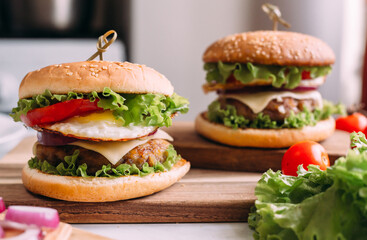 Two home made fresh tasty burgers with lettuce and cheese.