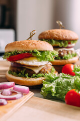 Two home made fresh tasty burgers with lettuce and cheese.