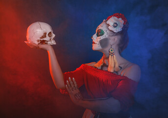 Beautiful woman with scary Halloween make up dead day calavera style with skull