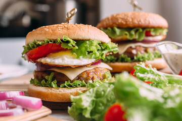 Two home made fresh tasty burgers with lettuce and cheese.