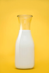 Milk bottle isolated on yellow background. Vertical photography.