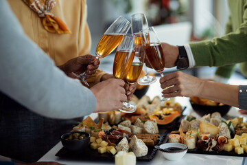 Close-up of coworkers toasting with Champagne on a party in the office.