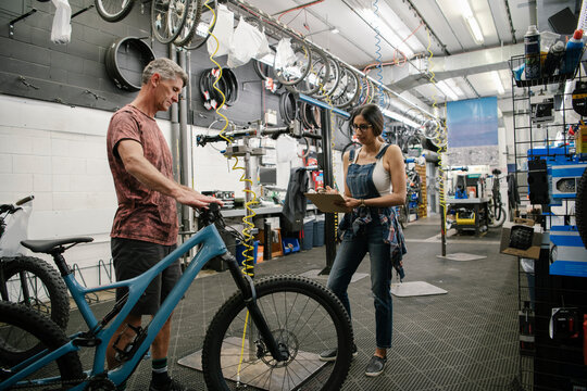 Bike shop mechanics fixing bicycle in workshop