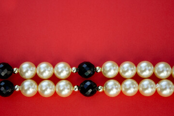 Old vintage necklace with pearl laying isolated on red background,fashion flat lay with retro bijouterie,print as postcard for mothers and womens day,greeting card,free place for text,copy space
