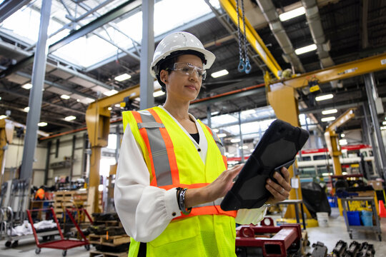 Portrait Of Woman With Digital Tablet Working In Maintenance Facility