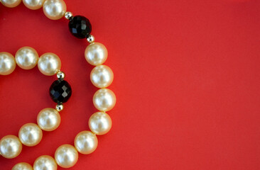 Old vintage necklace with pearl laying isolated on red background,fashion flat lay with retro bijouterie,print as postcard for mothers and womens day,greeting card,free place for text,copy space