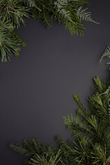 Christmas top view glamour layout frame made with evergreen fir branches on dark black background. Minimal winter or New Year concept with copy space. Flat lay, top view, greeting card.