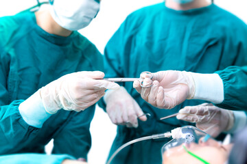 Doctors are treating patients in operating rooms. The doctor is holding surgical scissors.