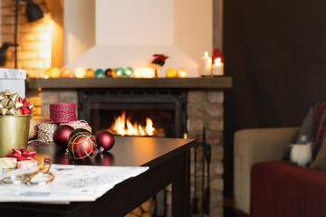 Gift workshop in a warm cozy room. Christmas decorations by fireplace.