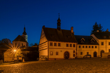 Fototapeta na wymiar Utery town in dark autumn night with church on hill and moon
