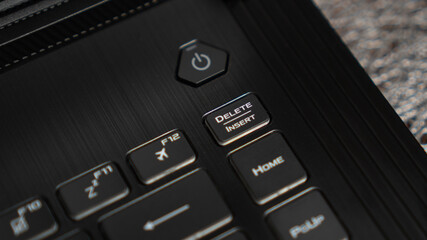 Close up the Delete key on the laptop keyboard. Insert key on keyboard. Modern black keyboard