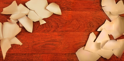 Torn paper pieces cut to ribbons on wooden desk background