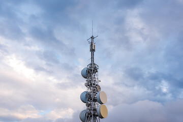 Telecommunication, television and radio antennas isolated over dramatic sky with clouds. industry...